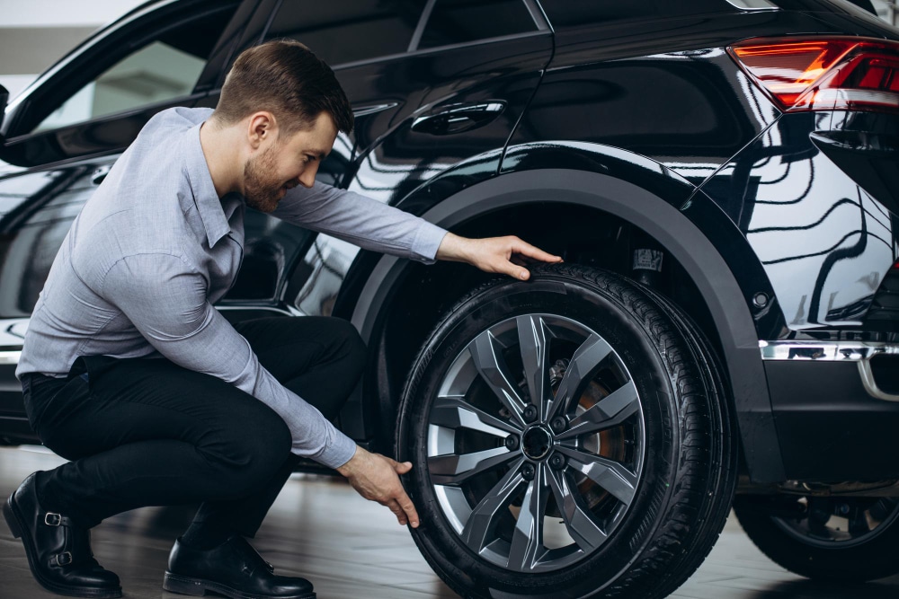 man choosing car and checking tires