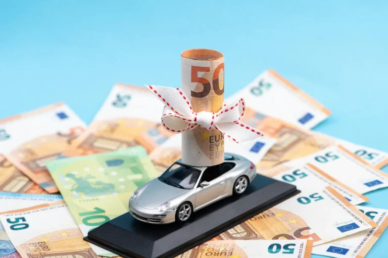 roll of euro money on an expensive car isolated on blue concept of prosperity wealth and gifts